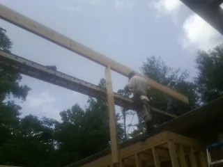 Carpenter setting a ridge beam over a new addition frame — Ice Dam Removal by Roofing Brothers in Elk Grove Village