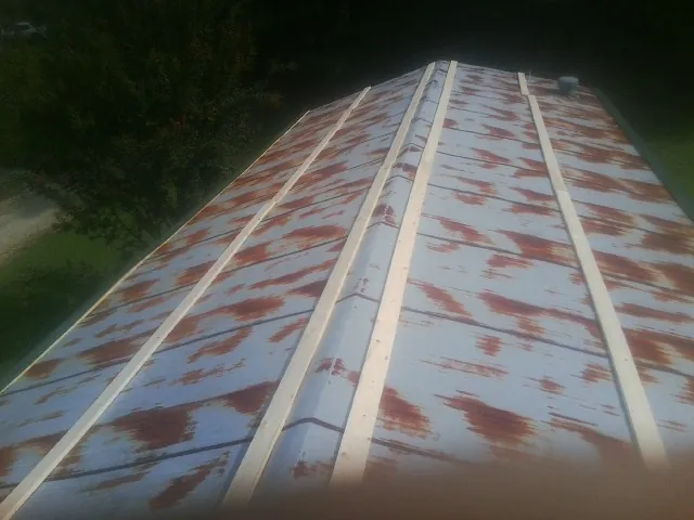 Rusted metal roof panels with new wood purlins before replacement in Elk Grove Village