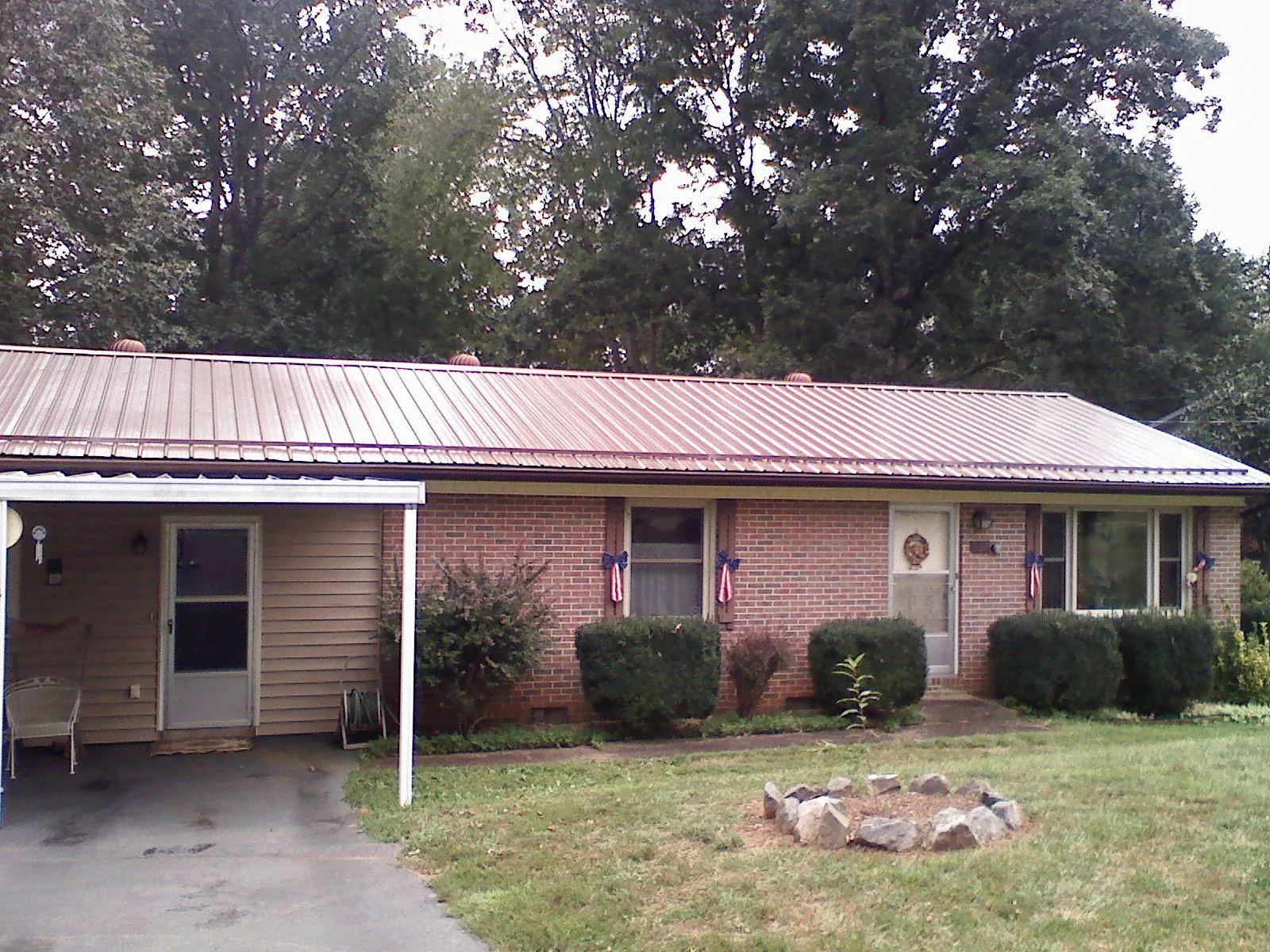 Bronze metal roof and carport on a brick ranch home — Roof Repair work by our crew in Elk Grove Village